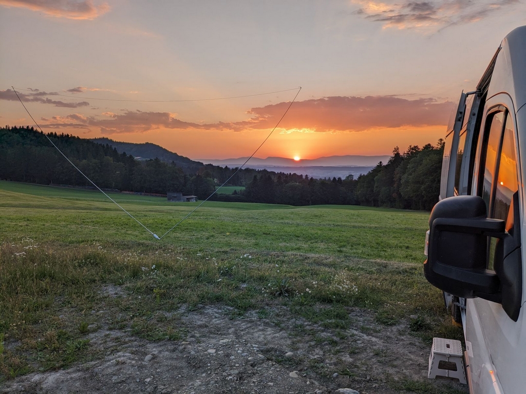 Antenne delta loop tendue devant le van au coucher de soleil sur les collines
