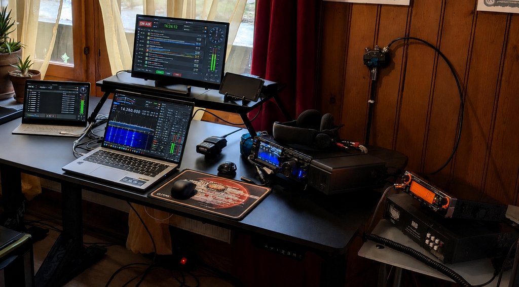 Vue d'ensemble du bureau du shack HB9VKL avec écrans, laptops et diplômes